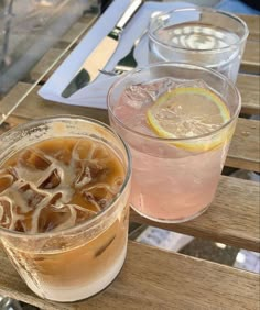 two drinks are sitting on a wooden table