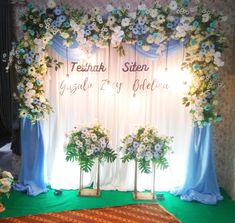 the backdrop is decorated with flowers and greenery