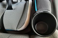 a dog is sitting in the back seat of a car next to a speaker and bag