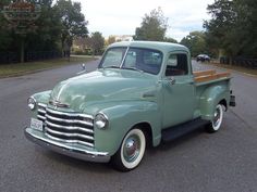 an old pick up truck parked in a parking lot