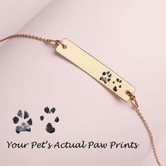 a dog's paw prints on a gold chain