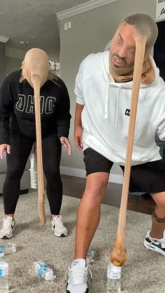 two people with baseball bats in their hands and one person wearing a mask on his head