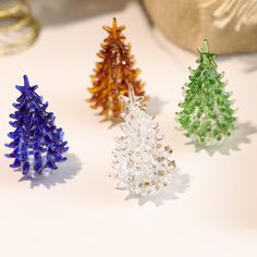 three small christmas trees sitting on top of a table