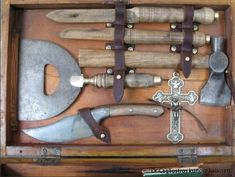 an old wooden box with tools in it and a cross on the front, inside