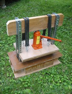 a bench that is sitting in the grass with some tools attached to it's back