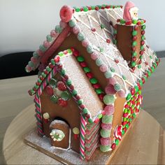 a decorated gingerbread house on top of a wooden table