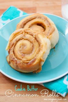 two cinnamon rolls sitting on top of a blue plate