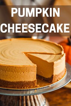 a pumpkin cheesecake on a cake plate with the words pumpkin cheesecake above it