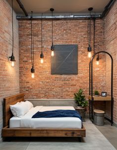 an industrial bedroom with brick walls and flooring, exposed lighting, and a bed