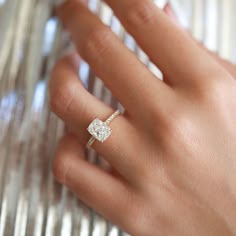 a woman's hand with a diamond ring on it