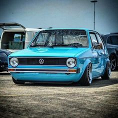 a blue vw golf wagon parked in a parking lot with other cars behind it