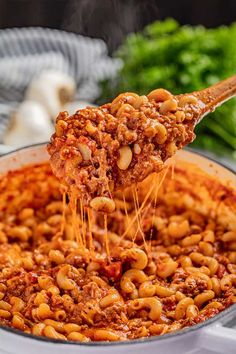 a ladle full of pasta being lifted from a pot