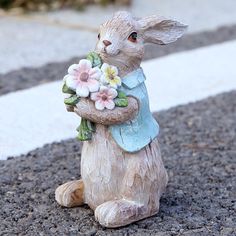 a small statue of a rabbit holding flowers