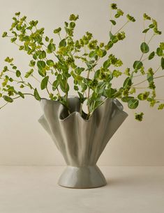 a vase filled with lots of green plants