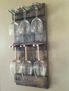 wine glasses are lined up on a wooden rack