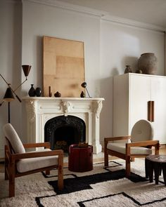 a living room filled with furniture and a fire place in front of a white fireplace