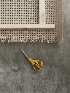 a pair of scissors sitting on top of a table next to a piece of cloth