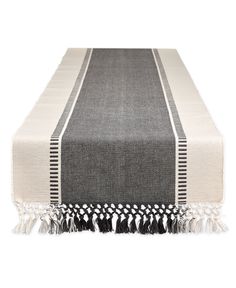 a black and white table runner with tassels