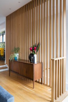 a living room with wooden slats on the wall and a table in front of it