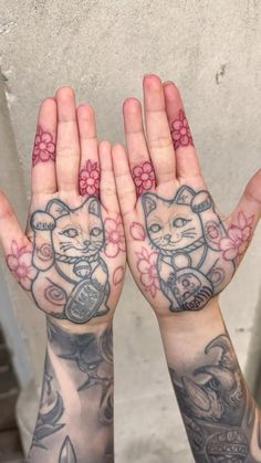 two hands that have tattoos on them and one has an image of a cat in the middle