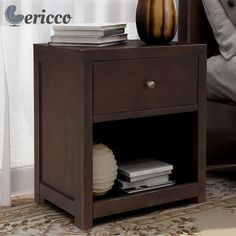 a night stand with books and a vase on it