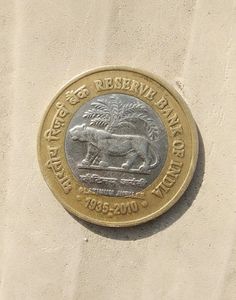 a gold and silver coin sitting on the side of a building