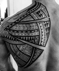 the back of a man's shoulder with an intricate tattoo design on his chest