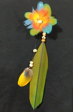 a colorful flower and feather decoration on a black background