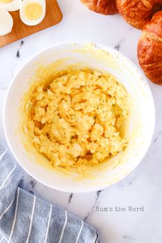 an image of scrambled eggs and croissants in a bowl on the counter