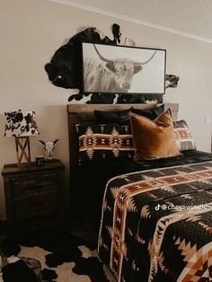 a bedroom with a cow head on the wall next to a black and white bed