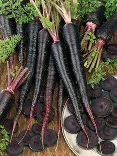 several bunches of purple carrots sitting on top of a plate