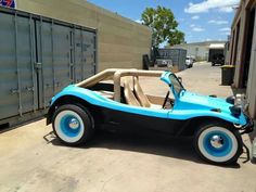 a blue and black car parked in front of a building