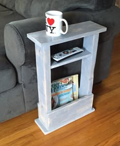 a coffee cup is sitting on top of a book shelf in front of a couch