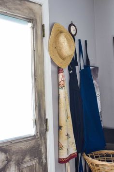 a hat, umbrella and other items are hanging on the wall next to an open door