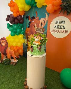 an animal themed birthday party with balloon arch and jungle animals on the wall behind it