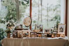 a table topped with pictures and flowers next to a window