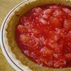 a close up of a pie crust on a table with tomatoes in the center and sauce in the middle