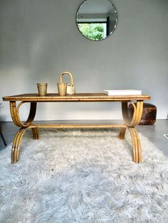 a wooden table sitting on top of a shaggy white rug next to a mirror and chair