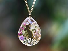 a tear shaped necklace with flowers in it