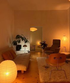 a living room filled with lots of furniture next to a wall mounted lamp on the wall