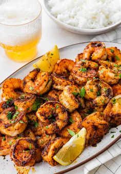 grilled shrimp with lemon and parsley served on a white plate next to rice