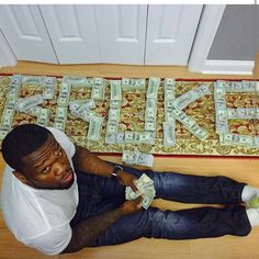 a man sitting on the floor with money in his hands