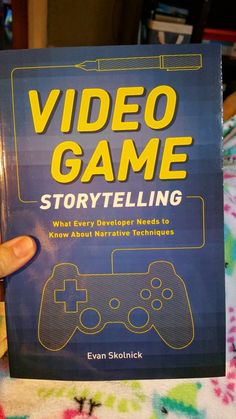 a book about video game storytelling is being held by a person's hand