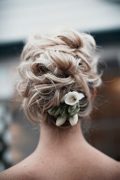 the back of a woman's head with flowers in her hair