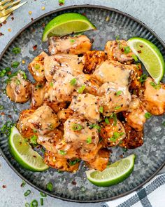 a plate with chicken and limes on it