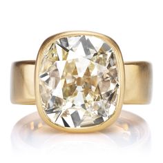 a yellow gold ring with an oval cut diamond in the center, on a white background