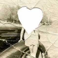 a black and white photo with a heart cut out on the back of a motorcycle