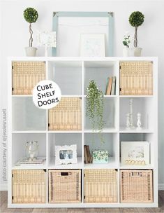 a white bookcase with wicker baskets on top and a blue mirror above it