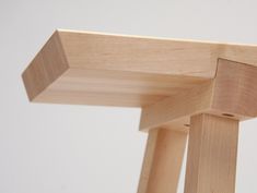 a close up view of the top of a wooden chair with one leg bent down