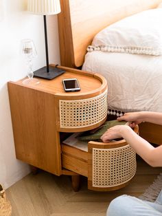 a woman sitting on the floor next to a bed